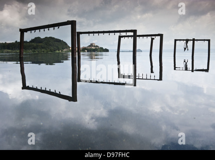 Il lago di Bolsena con acqua la riflessione e il piccolo villaggio di Capodimonte, Italia centrale Foto Stock