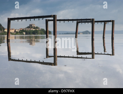 Il lago di Bolsena con acqua la riflessione e il piccolo villaggio di Capodimonte, Italia centrale Foto Stock