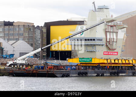 BAE Systems Shipyard, Scotstoun, Glasgow, Scozia, Regno Unito, giovedì, 13 giugno 2013. L'isola di poppa per la portaerei HMS Queen Elizabeth contenente il centro di controllo del traffico aereo che è fissato ad una chiatta sul fiume Clyde prima di navigare a Rosyth dove la nave è assemblata. Foto Stock