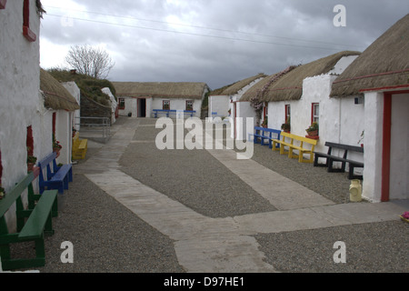 Ritratto di strada principale rivestita con crofters, cottage con il tetto di paglia a Doagh carestia villaggio in Donegal, Irlanda. Foto Stock