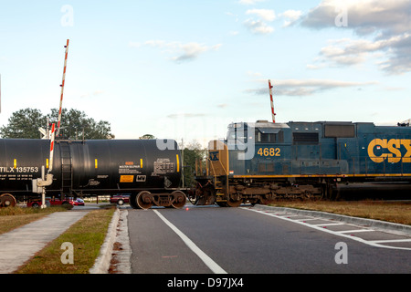 CSX 4682 motore tirando un treno merci comprendente un serbatoio nero auto attraverso un attraversamento ferroviario in Hawthorne, Florida. Foto Stock