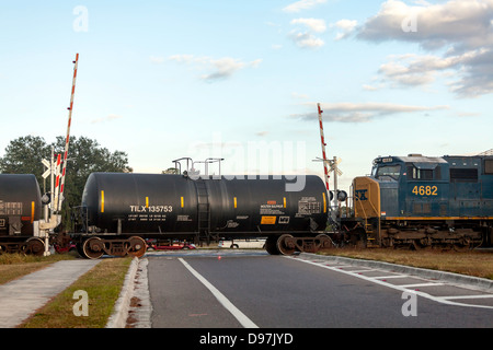 CSX 4682 motore tirando un treno merci comprese due serbatoio nero auto attraverso un attraversamento ferroviario in Hawthorne, Florida. Foto Stock