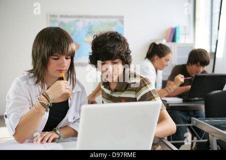 Gli alunni che studiano in una classe Foto Stock