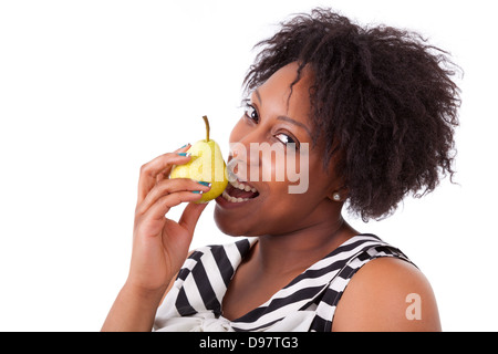 Il sovrappeso giovane nero donna mangiare una pera, isolati su sfondo bianco - popolo africano Foto Stock