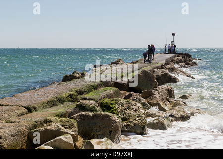 La pesca e la ricreazione su lunghi groyne / molo Hengistbury Head, Dorset, Costa Sud, Regno Unito Foto Stock