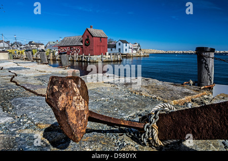 Un elemento di ancoraggio si siede in primo piano con un rosso baracca di pesca in background Foto Stock