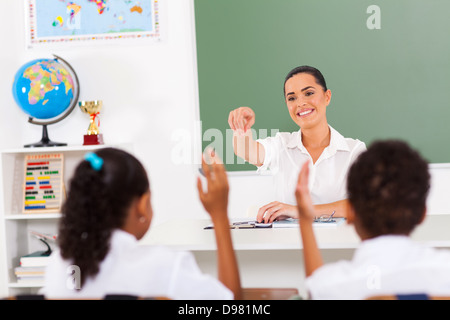 Insegnante elementare chiamando gli studenti in aula Foto Stock