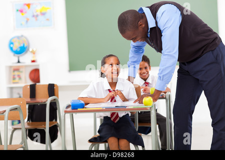 Insegnante elementare aiutare lo studente in aula Foto Stock