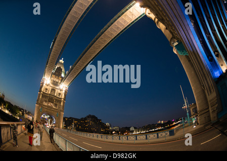 Tower Bridge at Night Londra Regno Unito // LONDRA, Regno Unito — Tower Bridge attraversa il Tamigi nel centro di Londra, collegando la Torre di Londra sulla riva nord con Southwark a sud. Completato nel 1894, il ponte in stile gotico vittoriano presenta due torri iconiche collegate da passaggi pedonali di alto livello e un meccanismo bascule che consente alla carreggiata di sollevarsi per il traffico fluviale. Il ponte è illuminato di notte con un sistema a LED a risparmio energetico installato nel 2012, che mette in risalto il suo caratteristico schema di colore blu e bianco. Il Tower Bridge si erge come uno dei quartieri più riconoscibili di Londra Foto Stock