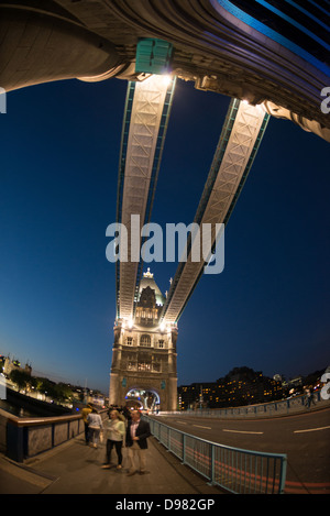 Tower Bridge at Night London // LONDRA, Regno Unito — Tower Bridge attraversa il Tamigi nel centro di Londra, collegando la Torre di Londra sulla riva nord con Southwark a sud. Completato nel 1894, il ponte in stile gotico vittoriano presenta due torri iconiche collegate da passaggi pedonali di alto livello e un meccanismo bascule che consente alla carreggiata di sollevarsi per il traffico fluviale. Il ponte è illuminato di notte con un sistema a LED a risparmio energetico installato nel 2012, che mette in risalto il suo caratteristico schema di colore blu e bianco. Il Tower Bridge si erge come uno dei monumenti e dei rem più riconoscibili di Londra Foto Stock