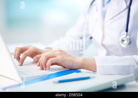 Close-up di un operatore sanitario la digitazione su laptop Foto Stock