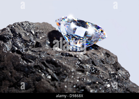 Foto di un unico taglio diamante su un pezzo di carbone contro uno sfondo semplice. Foto Stock