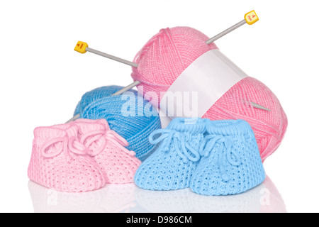 Maglia scarpine per bambini con blu e rosa lana plus degli aghi di tessitura, isolata su uno sfondo bianco. Foto Stock