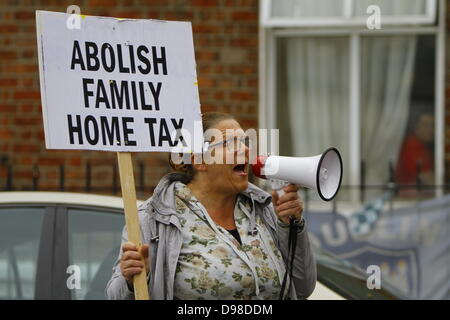 Dublino, Irlanda. 14 giugno 2013. Un manifestante detiene un cartello che recita "Abolire la casa di famiglia imposta" ed esclamazioni di slogan in ufficio il ministro Joan Burton è in visita a. Anti-tassa di uso domestico e anti-JobBridge manifestanti picketed il Ministro per la protezione sociale Joan Burton (Manodopera) durante la sua visita in un ufficio della nazionale irlandese di organizzazione dei disoccupati (INOU), chiamandola ad abolire la tassa per uso domestico e il tirocinante regime. Credito: Michael Debets/Alamy Live News Foto Stock