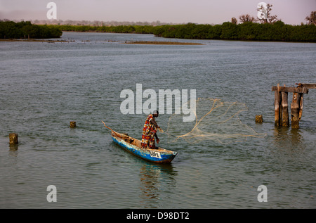 Senegal Africa Ovest Isola di Fadiouth pescatore netto di colata con canoa (piroga) Foto Stock