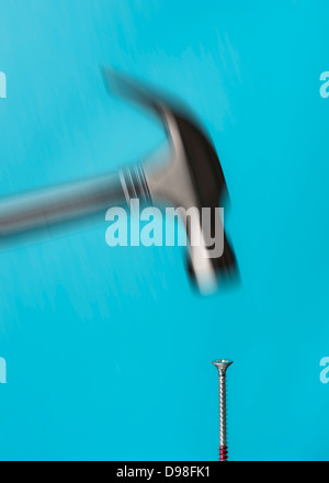 Moto sfocata del martello colpendo una vite Foto Stock