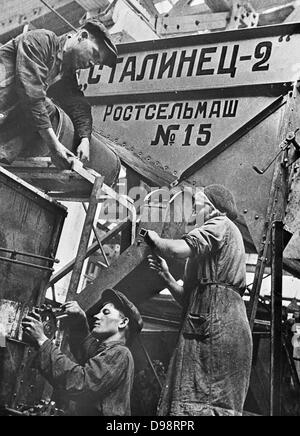 Gli uomini e le donne a lavorare su una trinciacaricatrice comibe in una fabbrica a Rostov-on-Don, Unione delle Repubbliche Socialiste Sovietiche (URSS), 1930-1940. La Russia Foto Stock