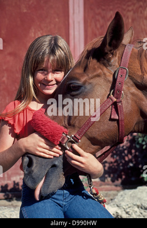 Una giovane ragazza e il suo cavallo di dimostrare il loro reciproco amore gli uni per gli altri presso un centro equestre nel sud della California, Stati Uniti d'America. Foto Stock