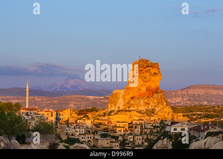 Vista sulla roccia nella luce del tramonto nel bagno turco piccola città Uchasir con coperte di neve montagna sullo sfondo Foto Stock