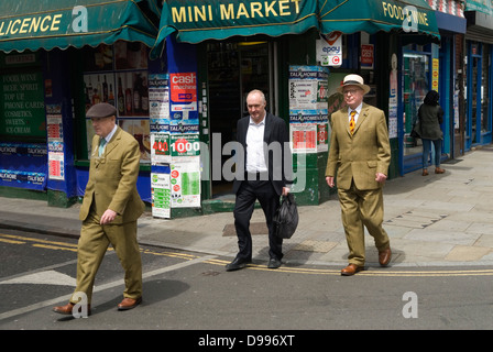 Gilbert e George (Gilbert Prousch, (L) uomo sconosciuto, George Passmore (R) ) artisti che indossano abiti dello stesso colore e scarpe marroni, camminano lungo Brick Lane, Tower Hamlets, East End Londra E1 Inghilterra 2013 2010s UK HOMER SYKES Foto Stock