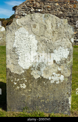 Vecchie pietre tombali ricoperte da licheni presso San Brynach Chiesa del Galles Foto Stock