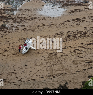 Un piccolo yacht arenati su una spiaggia di sabbia Foto Stock