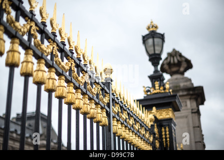 Porte dorate del Palazzo Reale di Bruxelles Bruxelles Belgio | BRUXELLES, Belgio — Termini a forma di lancia dorati e un lampione sormontato da una corona segnano la ringhiera perimetrale del Palazzo Reale di Bruxelles. Le cancelli in ferro battuto risalgono per lo più alla ristrutturazione del palazzo all’inizio del XX secolo sotto il re Leopoldo II, il cui architetto Henri Maquet ricostruì la facciata nord in pietra calcarea bianca di Euville entro il 1911. Il palazzo funge da sede amministrativa del Re; la famiglia reale vive al Castello di Laeken fuori dal centro città. Foto Stock