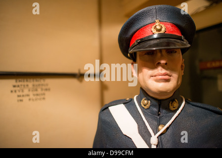 LONDRA, Regno Unito — Un manequino a grandezza naturale di una guardia alle Churchill War Rooms di Londra. Il museo, uno dei cinque rami del Museo della Guerra Imeriale, conserva il bunker di comando sotterraneo della seconda guerra mondiale utilizzato dal primo ministro britannico Winston Churchill. I suoi quartieri ristretti furono costruiti da un seminterrato di deposito convertito nel Treasury Building di Whitehall, Londra. Essendo sotterranea, e sotto un edificio insolitamente robusto, le Cabinet War Rooms ricevettero una certa protezione dalle bombe che cadono sopra durante il Blitz. Foto Stock