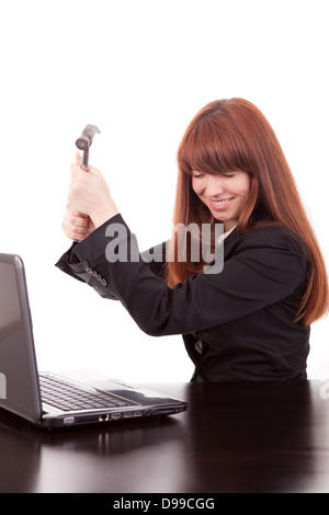 Fustrated imprenditore nel suo ufficio che minacciano di distruggere il suo PC con un martello di pura frustrazione Foto Stock