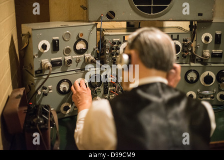 LONDRA, Regno Unito — Un manequino di un operatore radio presso le Churchill War Rooms di Londra. Il museo, uno dei cinque rami del Museo della Guerra Imeriale, conserva il bunker di comando sotterraneo della seconda guerra mondiale utilizzato dal primo ministro britannico Winston Churchill. I suoi quartieri ristretti furono costruiti da un seminterrato di deposito convertito nel Treasury Building di Whitehall, Londra. Essendo sotterranea, e sotto un edificio insolitamente robusto, le Cabinet War Rooms ricevettero una certa protezione dalle bombe che cadono sopra durante il Blitz. Foto Stock