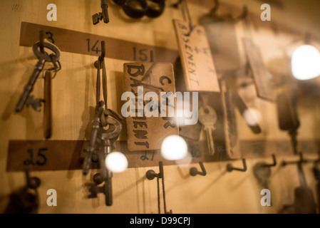 Churchill War Rooms Keys Londra / LONDRA, Regno Unito - le chiavi d'epoca recanti le etichette "C.W.R BASEMENT" sono appese su una tavola di legno dietro il vetro delle Churchill War Rooms. Questo bunker di comando sotterraneo, ora conservato come un ramo dell'Imperial War Museums, fu utilizzato dal primo ministro britannico Winston Churchill durante la seconda guerra mondiale. Gli stretti quartieri amministrativi furono costruiti convertendo un deposito sotterraneo sotto l'edificio dell'Office of Works a Whitehall, offrendo protezione vitale dai bombardamenti tedeschi durante il Blitz. Foto Stock