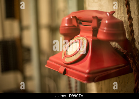 LONDRA, Regno Unito — Un telefono rosso al Churchill War Rooms di Londra. Il museo, uno dei cinque rami del Museo della Guerra Imeriale, conserva il bunker di comando sotterraneo della seconda guerra mondiale utilizzato dal primo ministro britannico Winston Churchill. I suoi quartieri ristretti furono costruiti da un seminterrato di deposito convertito nel Treasury Building di Whitehall, Londra. Essendo sotterranea, e sotto un edificio insolitamente robusto, le Cabinet War Rooms ricevettero una certa protezione dalle bombe che cadono sopra durante il Blitz. Foto Stock