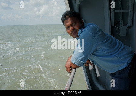 Uomo di mezza età appoggiata sulla ringhiera di una nave Foto Stock