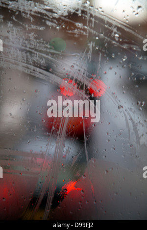 Sfocata traffico attraverso bagnato nella finestra di Bus Foto Stock