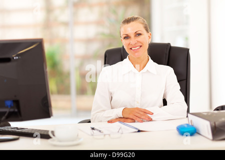 Senior imprenditrice seduti nella parte anteriore della scrivania in ufficio Foto Stock