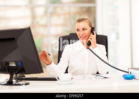 Felice di mezza età imprenditrice lavoro in ufficio Foto Stock