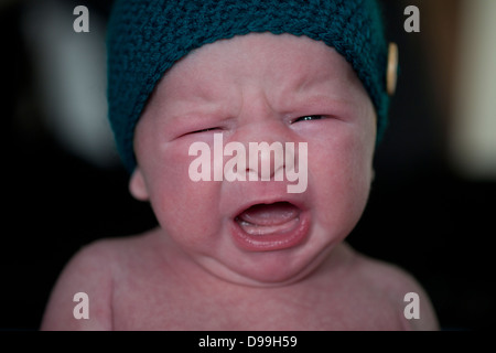 Rosso di fronte neonato sconvolto e pianto Foto Stock