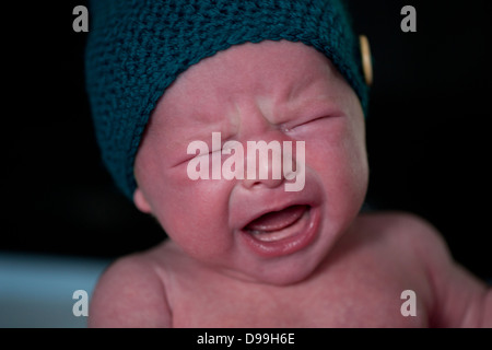 Rosso di fronte neonato sconvolto e pianto Foto Stock