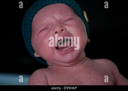 Rosso di fronte neonato sconvolto e pianto Foto Stock