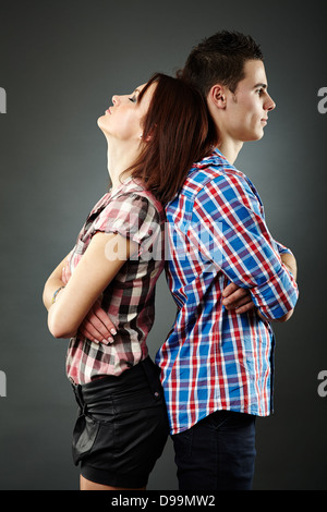 Primo piano della triste coppia giovane in piedi di schiena,aventi difficoltà di relazione. Sfondo grigio Foto Stock