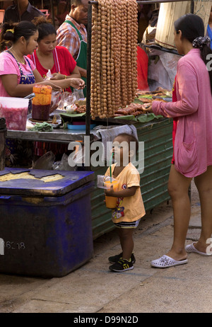 WAT MERCATO KARON, KARON, Phuket, Thailandia Febbraio 16 2013: Toddler detiene il bicchiere di aranciata in stallo alimentare Foto Stock