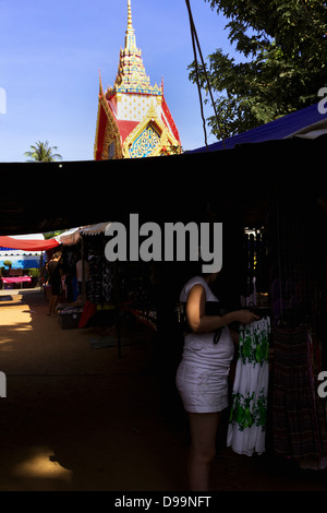 WAT MERCATO KARON, KARON, Phuket, Thailandia Febbraio 16 2013: Donna guarda i vestiti per la vendita sul giorno di mercato, Tempio Karon Foto Stock