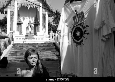 WAT MERCATO KARON, KARON, Phuket, Thailandia Febbraio 16 2013: passeggiate turistiche da T-shirt appeso davanti un tempio stupa Foto Stock