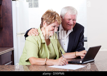 Felice coppia senior utilizzando internet banking controllo saldo bancario Foto Stock