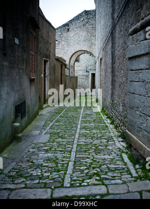 Una strada di ciottoli in scena la cittadina medievale di Erice in provincia di Trapani, in Sicilia. Foto Stock