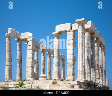 Tempio di Poseidone, un antico santuario religioso greco costruito sulla punta della penisola Attica da marmo bianco quarried locale, con cielo blu Foto Stock