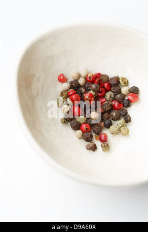 Ciotola bianco con varietà di grano di pepe Foto Stock