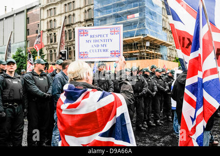 Belfast, Regno Unito. Il 15 giugno, 2013. Bandiera protesta coincide con proteste anti-G8 a Belfast. Un manifestante femmina trattiene un banner dicendo 'Rispetto la mia identità e la mia cultura' davanti a decine di funzionari di polizia Credit: stephen Barnes/Alamy Live News Foto Stock