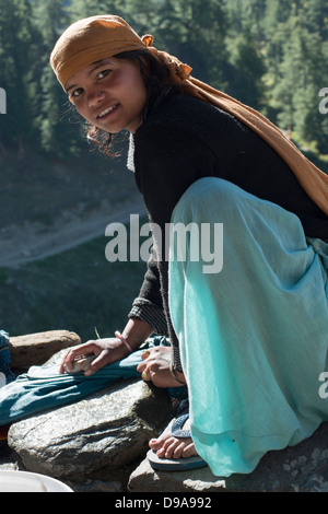 Un giovane Gaddi tribeswoman lavaggi della famiglia indumenti al villaggio himalayana di Kugti in Himachal Pradesh, India Foto Stock