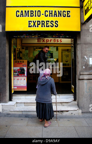 Donna gitana per l'accattonaggio denaro al di fuori di Western Union, Madrid , Spagna Foto Stock